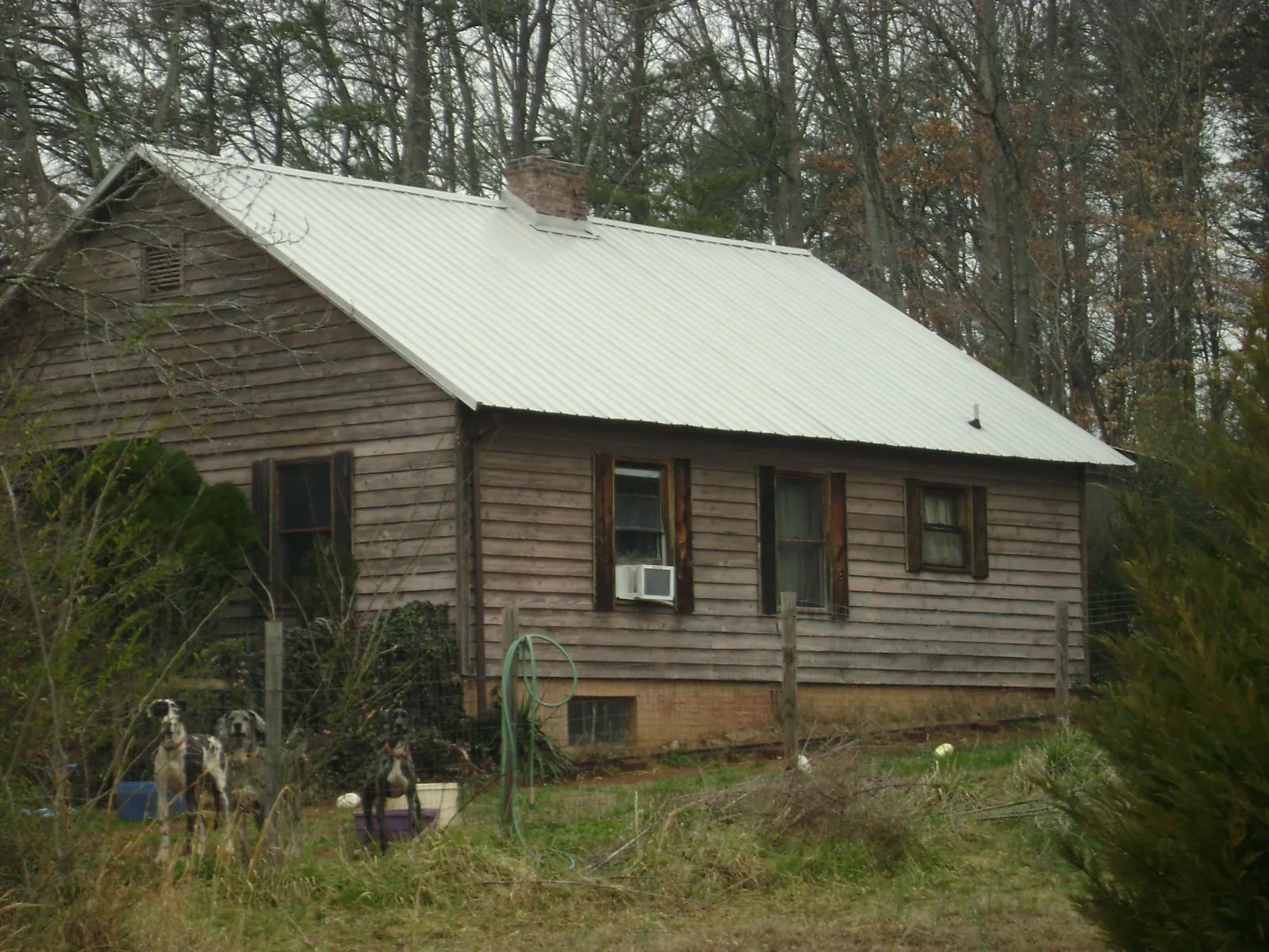 White metal roof on an old wood sided farmhouse, from a Metal Roof Installation job in Baltic